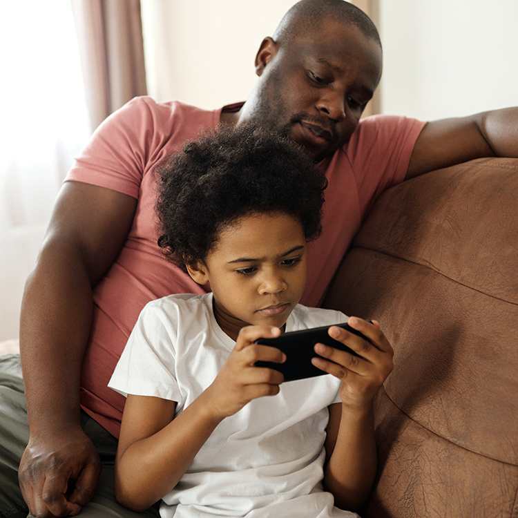 Stock image of a family using a mobile phone together.